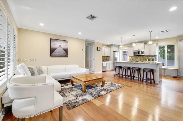 a living room with furniture and a kitchen view