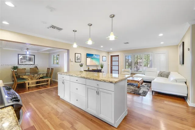 a large living room with stainless steel appliances granite countertop a couch dining table chairs and view living room