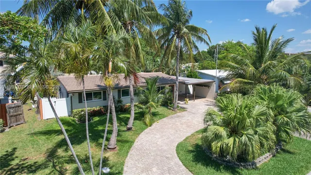 a view of a house with a yard and potted plants