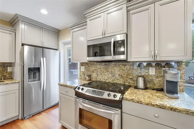 a kitchen with stainless steel appliances granite countertop a refrigerator sink and stove