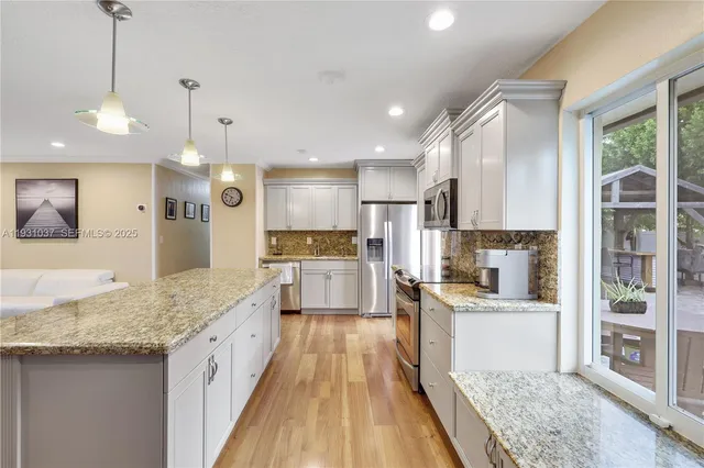 a large kitchen with kitchen island a large counter space a sink appliances and cabinets