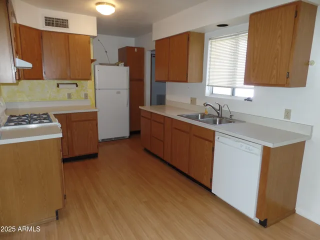 a room with a sink a refrigerator and a stove top oven