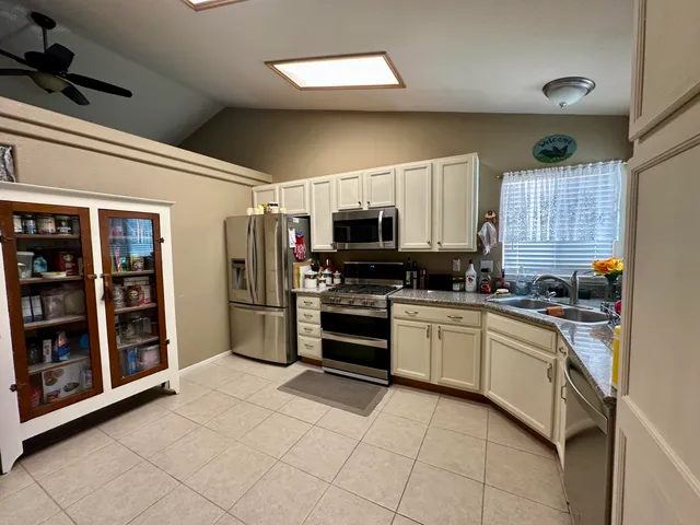 a kitchen with stainless steel appliances granite countertop a refrigerator and a stove top oven