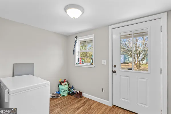 a view of hallway with window and wooden floor