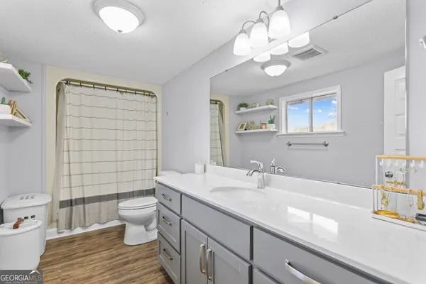 a bathroom with a sink a toilet and a large mirror