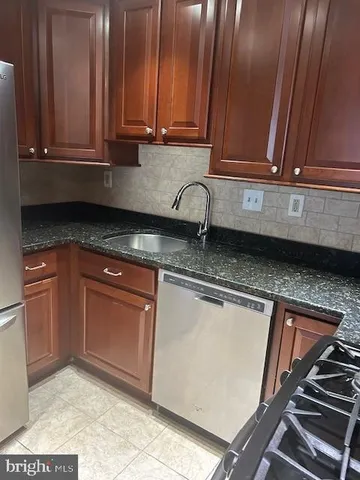 a kitchen with granite countertop a sink a stove and cabinets