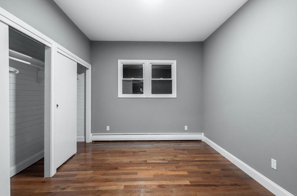 522 Broadway Fall River, MA 02724 - Photo 14 of 15 an empty room with wooden floor and windows