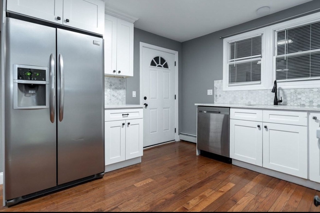 522 Broadway Fall River, MA 02724 - Photo 3 of 15 a kitchen with white cabinets and refrigerator