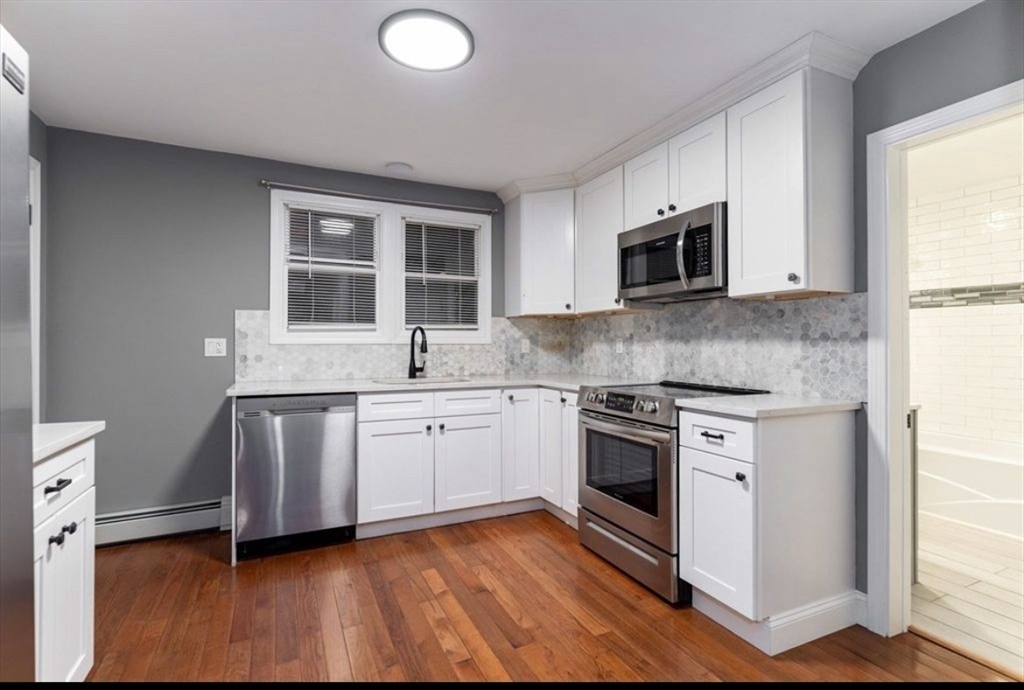 522 Broadway Fall River, MA 02724 - Photo 4 of 15 a kitchen with stainless steel appliances granite countertop a stove a sink and a microwave