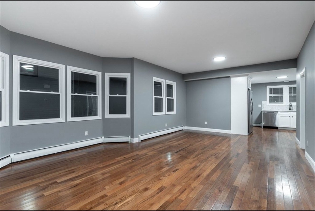 522 Broadway Fall River, MA 02724 - Photo 6 of 15 a view of an empty room with wooden floor and a window