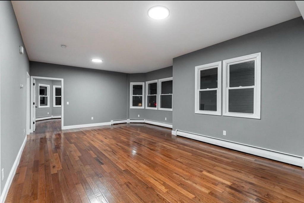 522 Broadway Fall River, MA 02724 - Photo 8 of 15 a view of an empty room with wooden floor and windows