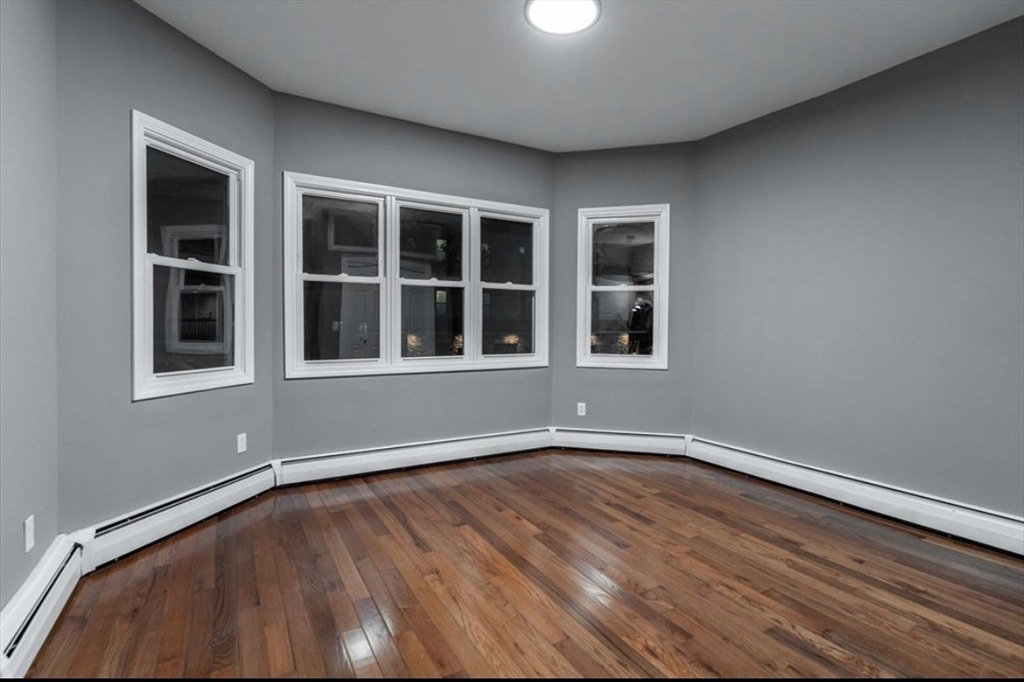 522 Broadway Fall River, MA 02724 - Photo 9 of 15 an empty room with wooden floor and windows