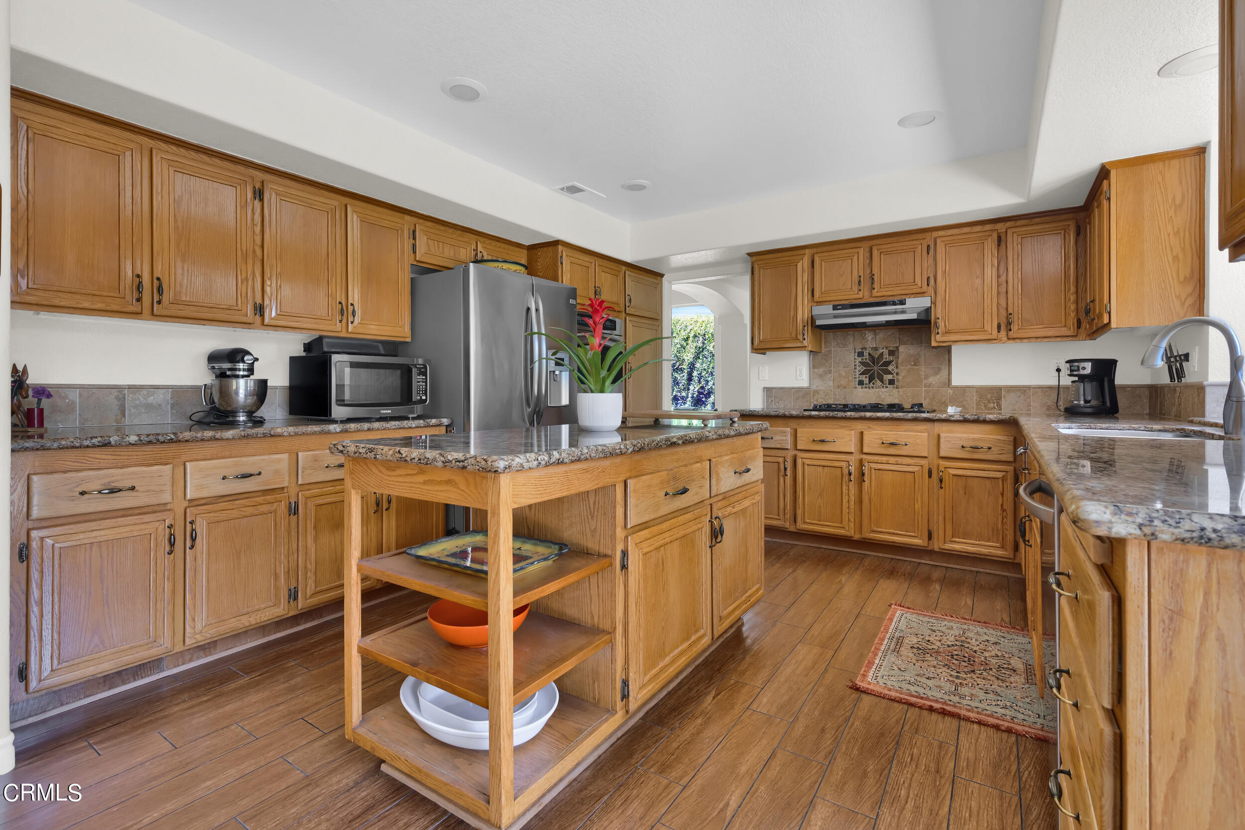 20182 Hill Spring Road Wildomar, CA 92595 - Photo 13 of 47 a kitchen with stainless steel appliances a sink wooden cabinets and counter space