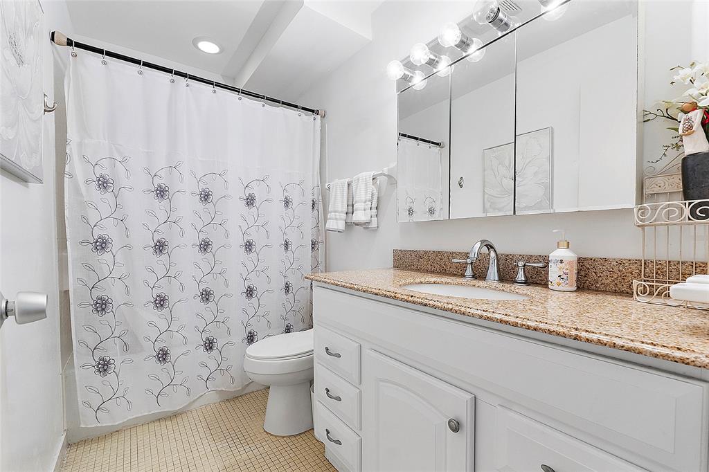 1481 South Ocean Boulevard, Unit 416A Lauderdale-by-the-Sea, FL 33062 - Photo 12 of 16 a bathroom with a granite countertop sink a toilet and a shower