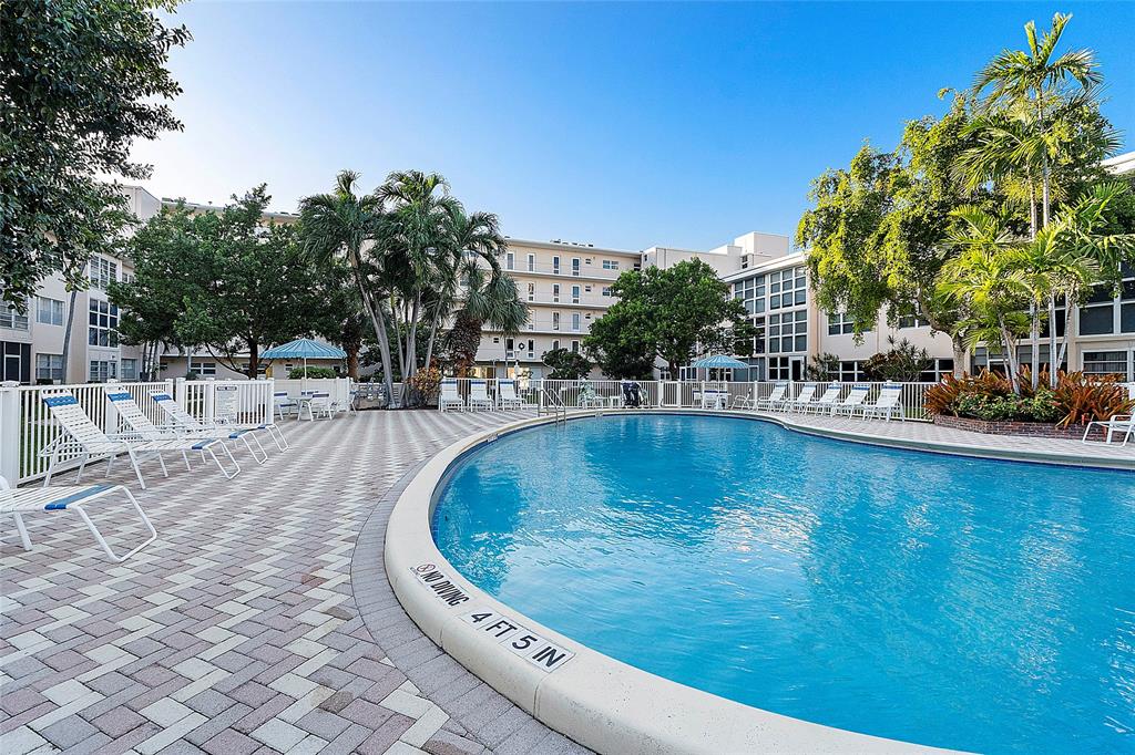 1481 South Ocean Boulevard, Unit 416A Lauderdale-by-the-Sea, FL 33062 - Photo 2 of 16 a view of swimming pool with outdoor seating and plants