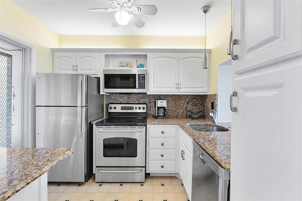 1481 South Ocean Boulevard, Unit 416A Lauderdale-by-the-Sea, FL 33062 - Photo 5 of 16 a kitchen with a stove refrigerator and microwave