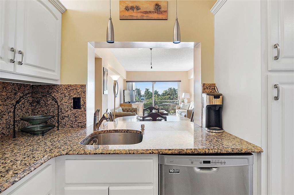 1481 South Ocean Boulevard, Unit 416A Lauderdale-by-the-Sea, FL 33062 - Photo 6 of 16 a kitchen with a sink and a refrigerator