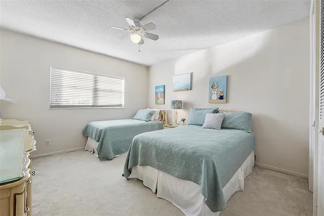 a spacious bedroom with two beds and a chandelier