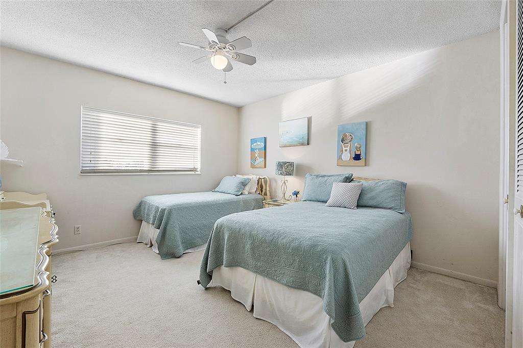 1481 South Ocean Boulevard, Unit 416A Lauderdale-by-the-Sea, FL 33062 - Photo 10 of 16 a spacious bedroom with two beds and a chandelier