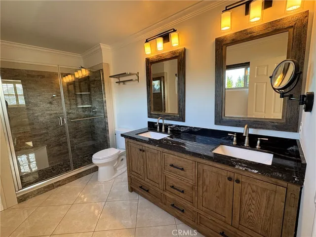 a bathroom with a granite countertop toilet sink shower and mirror