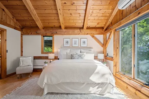 a large bed sitting in a bedroom next to a window