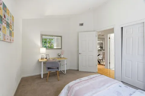 a bedroom with a chair and a table in it
