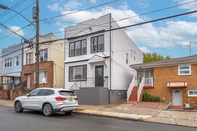 a car parked in front of a white house