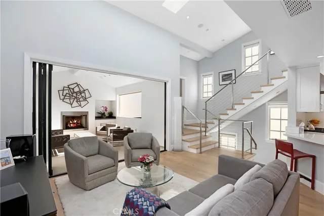 a living room with furniture kitchen view and a wooden floor