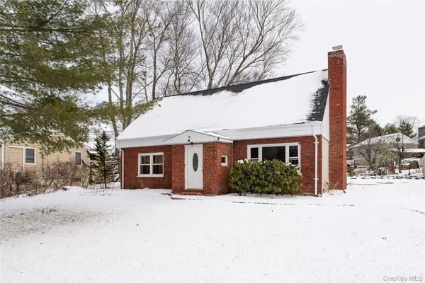 a front view of a house with a yard covered in snow