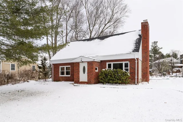 a front view of a house with a yard covered in snow