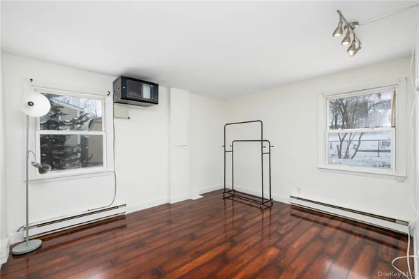 a view of empty room with wooden floor and window