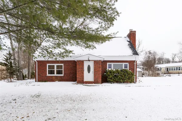 a front view of a house with a yard covered in snow