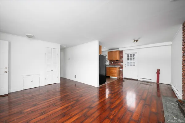 a view of a hardwood floor in a room with a kitchen