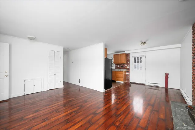 a view of a hardwood floor in a room with a kitchen