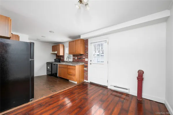 a kitchen with granite countertop a refrigerator and a sink