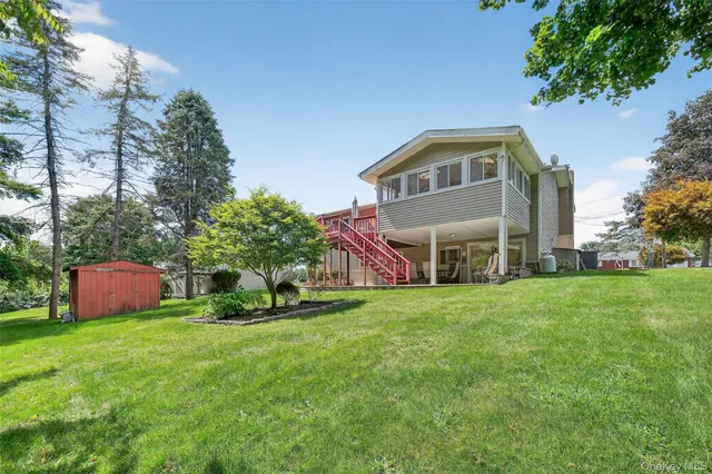 a front view of house with yard and trees in the background