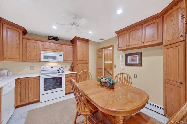 a kitchen with stainless steel appliances granite countertop a stove a sink dishwasher a dining table and chairs with wooden floor