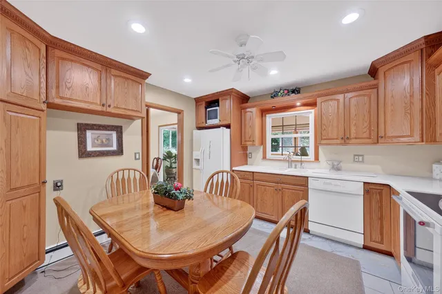 a dining room with stainless steel appliances kitchen island granite countertop a sink a stove a dining table and chairs with wooden floor