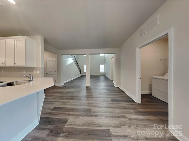 a view of a kitchen with wooden floor and a sink