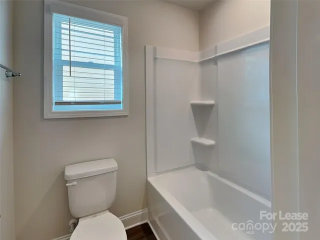 a white toilet sitting next to a bath tub