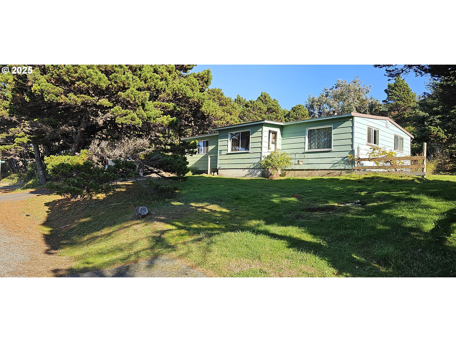 33261 Ophir Road Gold Beach, OR 97444 - Photo 1 of 36 a view of a yard in front of a house with a large tree
