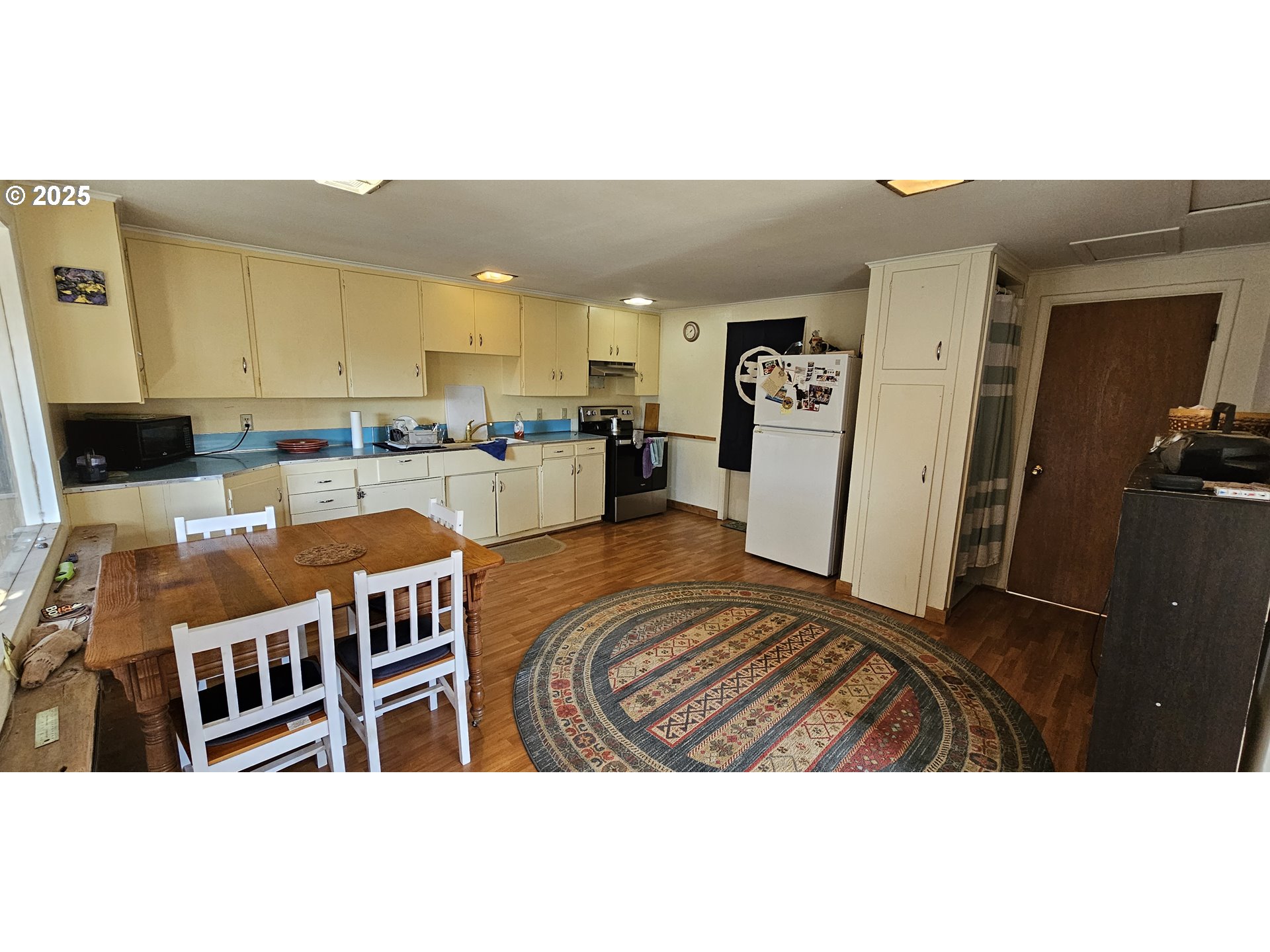 33261 Ophir Road Gold Beach, OR 97444 - Photo 6 of 36 a kitchen view with granite countertop a refrigerator a stove a sink dishwasher and white cabinets with wooden floor