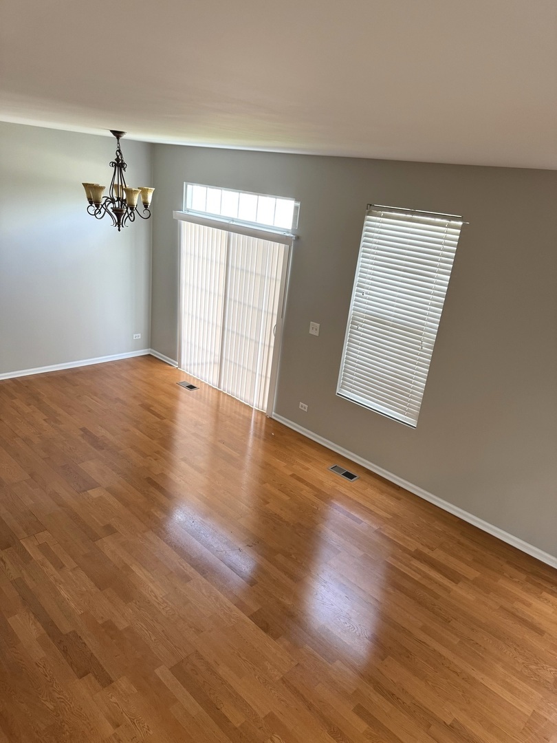 537 North Red Deer Road Round Lake, IL 60073 - Photo 2 of 12 a view of empty room with wooden floor and fan
