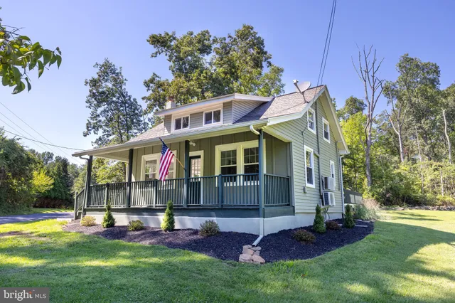 a view of an house with backyard and a tree