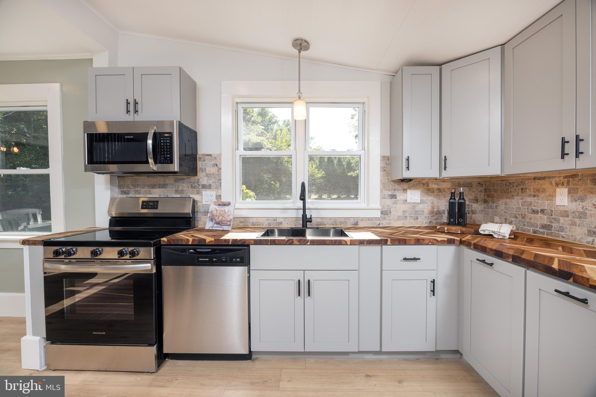107 Rock Ridge Road Ottsville, PA 18942 - Photo 7 of 24 a kitchen with stainless steel appliances granite countertop a stove a sink and a microwave