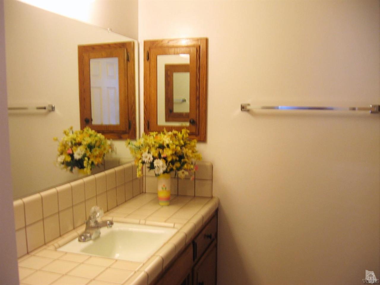 22813 Clover Spring Place Tehachapi, CA 93561 - Photo 14 of 20 a bathroom with a granite countertop sink and a mirror