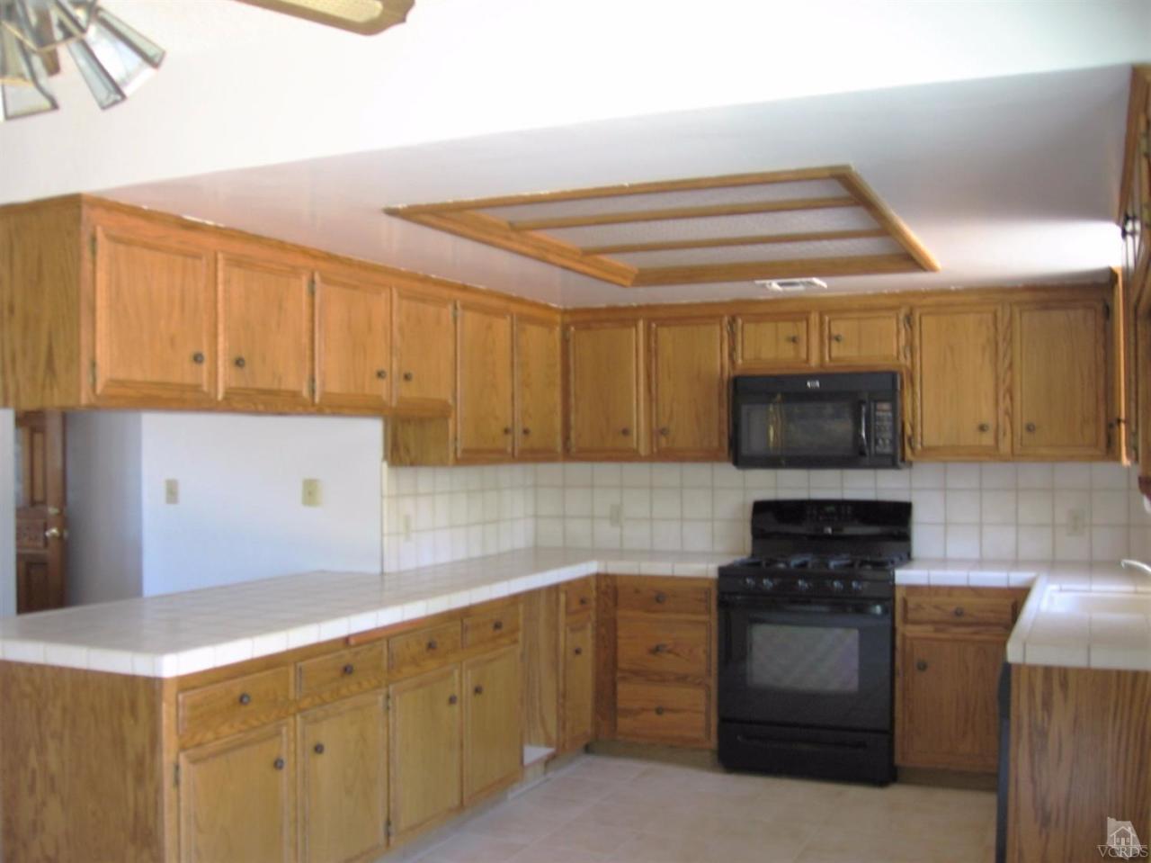 22813 Clover Spring Place Tehachapi, CA 93561 - Photo 7 of 20 a kitchen with stainless steel appliances granite countertop a stove and a sink