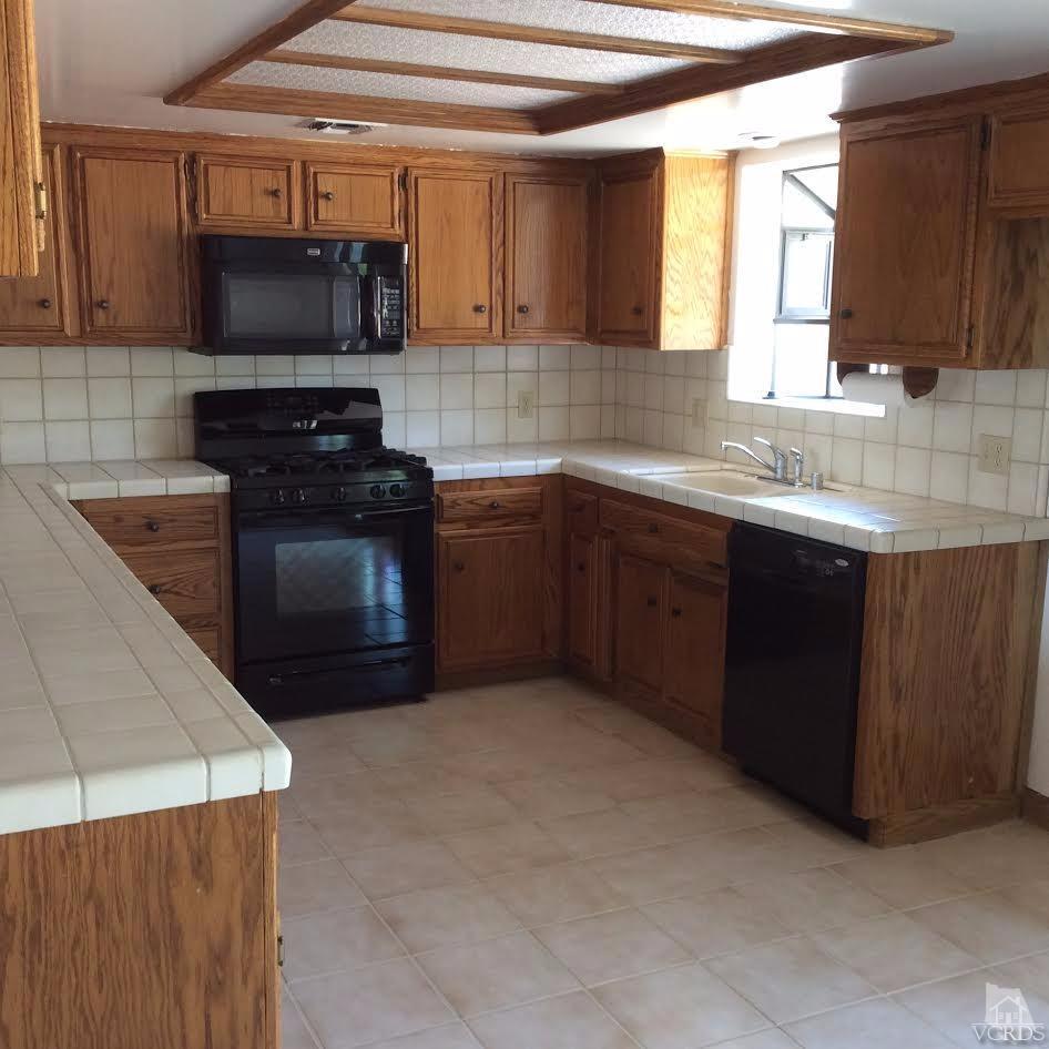 22813 Clover Spring Place Tehachapi, CA 93561 - Photo 9 of 20 a kitchen with stainless steel appliances granite countertop a sink and a stove