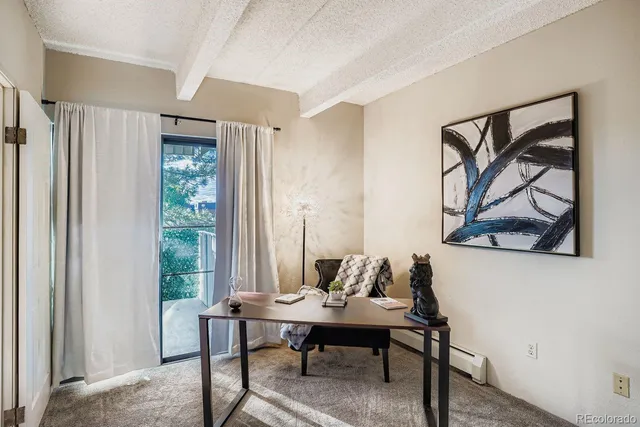 a view of a workspace with furniture and a window