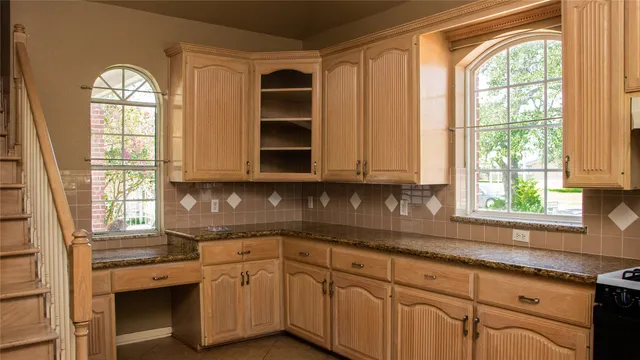 a kitchen with stainless steel appliances white cabinets and a window